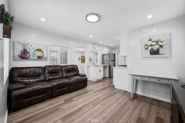 living room with light hardwood / wood-style floors and sink