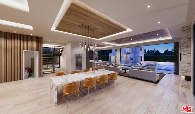 interior space featuring a notable chandelier, light hardwood / wood-style floors, and a raised ceiling