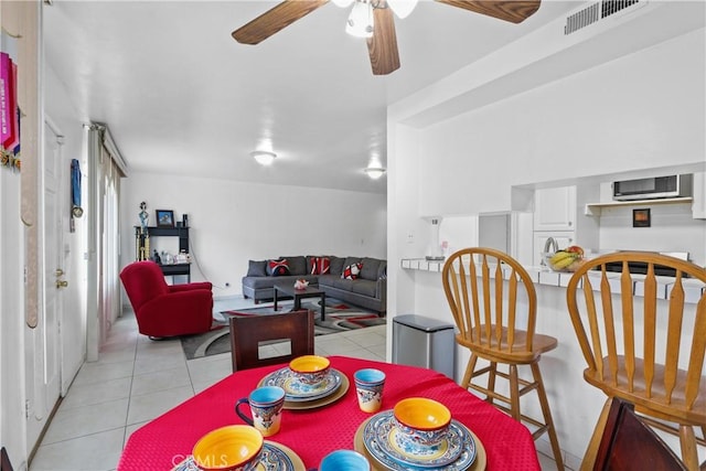 tiled dining area with ceiling fan