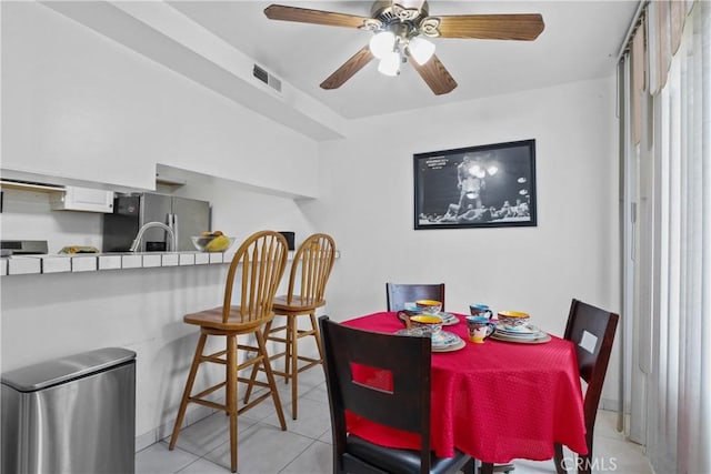 dining area with light tile patterned floors and ceiling fan