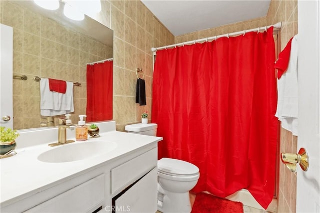 bathroom with vanity, toilet, tile walls, and curtained shower