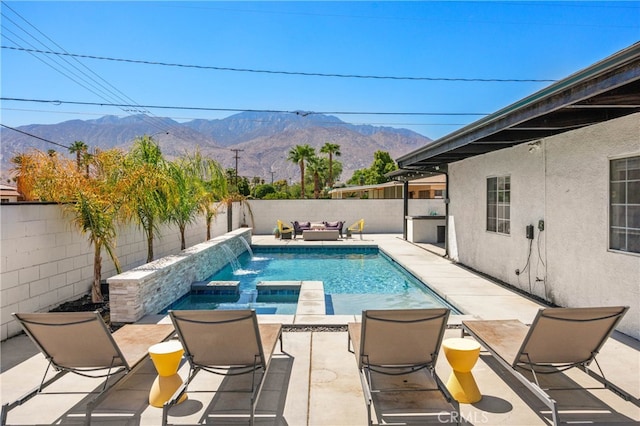 view of swimming pool with a patio, an in ground hot tub, a mountain view, and pool water feature