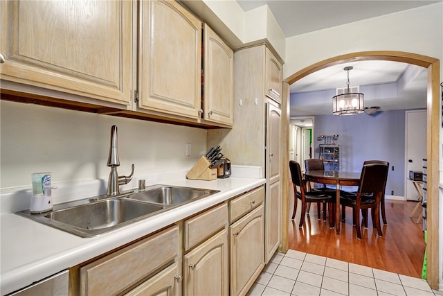 kitchen with sink, an inviting chandelier, light hardwood / wood-style flooring, light brown cabinetry, and decorative light fixtures