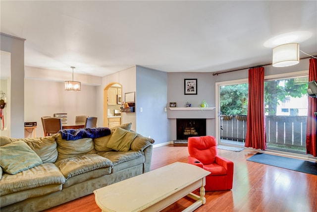 living room featuring a chandelier and light hardwood / wood-style flooring