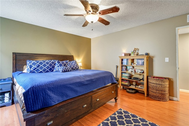 bedroom featuring light wood-type flooring, ceiling fan, and a textured ceiling