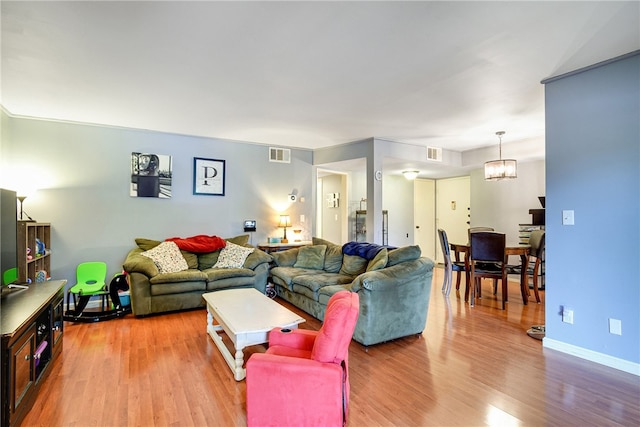 living room featuring hardwood / wood-style flooring and a notable chandelier