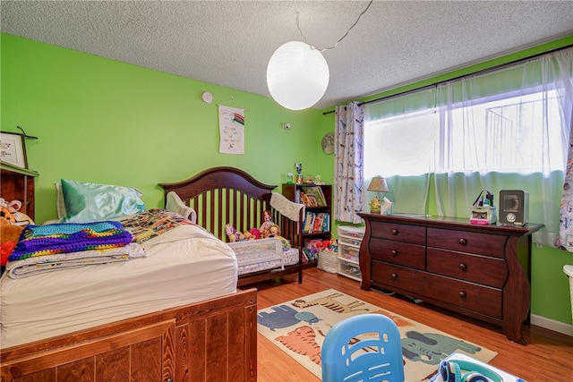 bedroom featuring hardwood / wood-style flooring and a textured ceiling