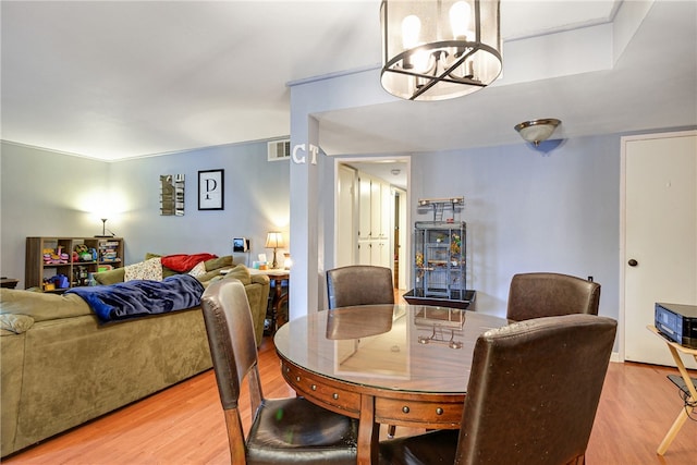 dining space with a chandelier and light hardwood / wood-style floors