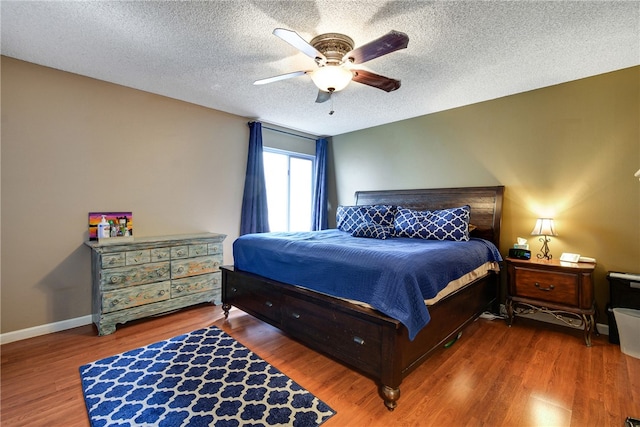 bedroom featuring ceiling fan, a textured ceiling, and wood-type flooring