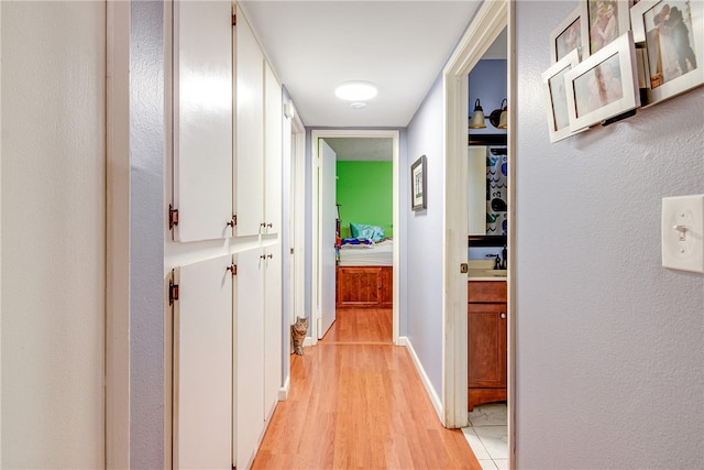 corridor featuring sink and light wood-type flooring