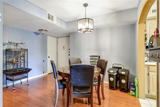 dining area with a chandelier and light hardwood / wood-style floors