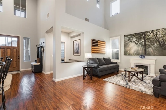 living room with a high ceiling and dark hardwood / wood-style floors