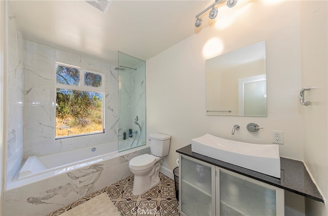 full bathroom with tiled shower / bath combo, vanity, toilet, and tile patterned floors