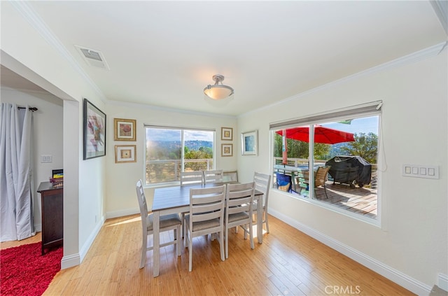 dining room with light hardwood / wood-style flooring and ornamental molding