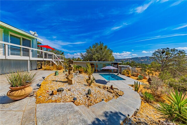 view of pool featuring a hot tub, a mountain view, and a patio area