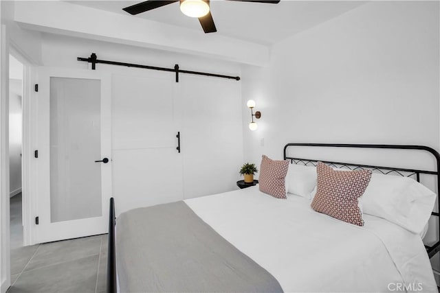 bedroom featuring a closet, a barn door, and ceiling fan