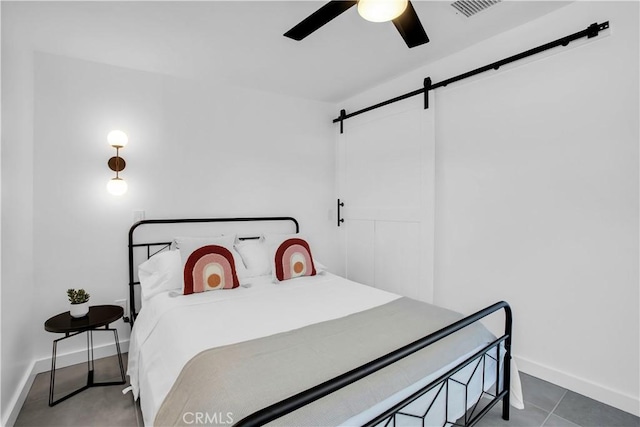 bedroom with a barn door and ceiling fan