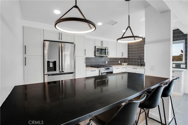 kitchen featuring pendant lighting, white cabinets, and appliances with stainless steel finishes