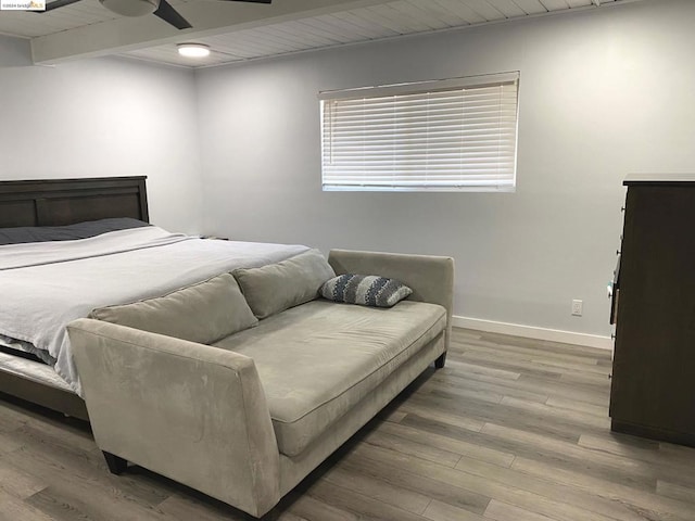 bedroom with beamed ceiling, hardwood / wood-style floors, and ceiling fan