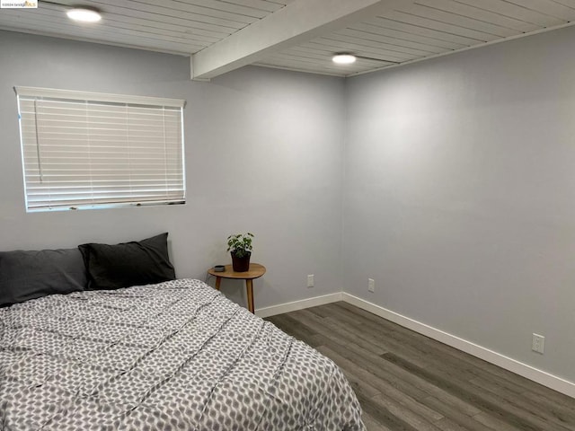 bedroom with beamed ceiling and dark hardwood / wood-style flooring