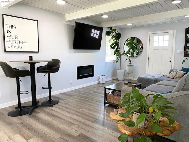 living room featuring beamed ceiling and hardwood / wood-style floors