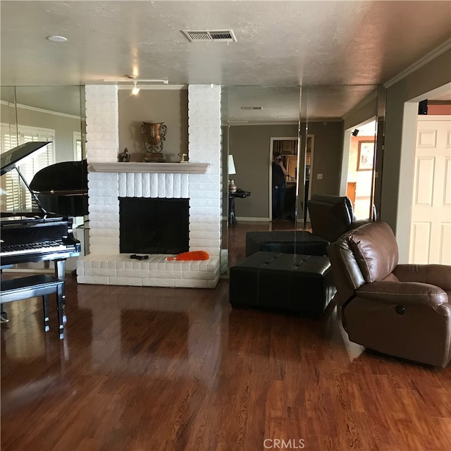 living room featuring a brick fireplace, crown molding, and hardwood / wood-style flooring