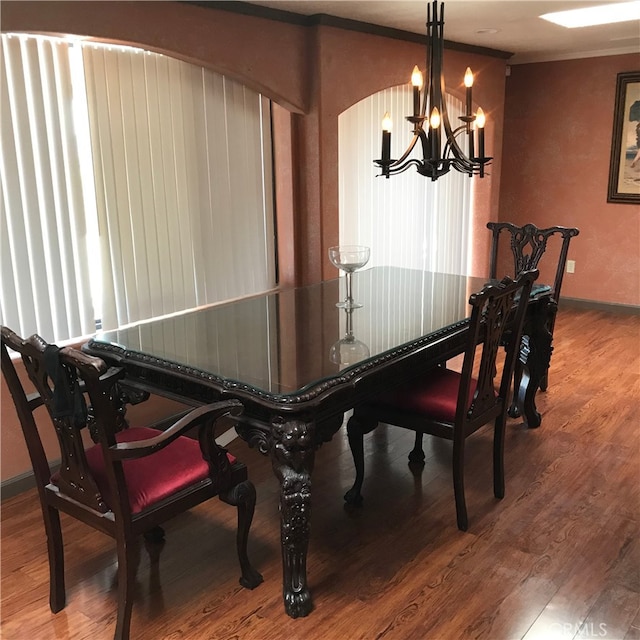 dining area with crown molding, a chandelier, and hardwood / wood-style flooring