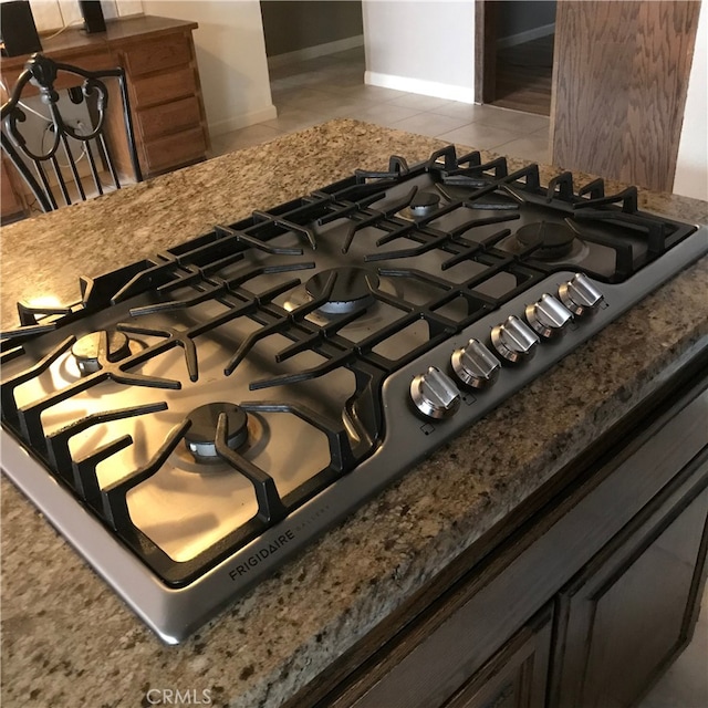 room details with stone countertops and stainless steel gas cooktop