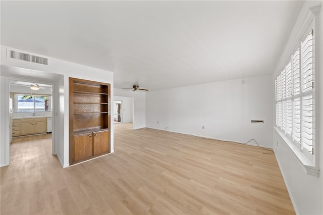 unfurnished living room featuring light wood-type flooring and sink