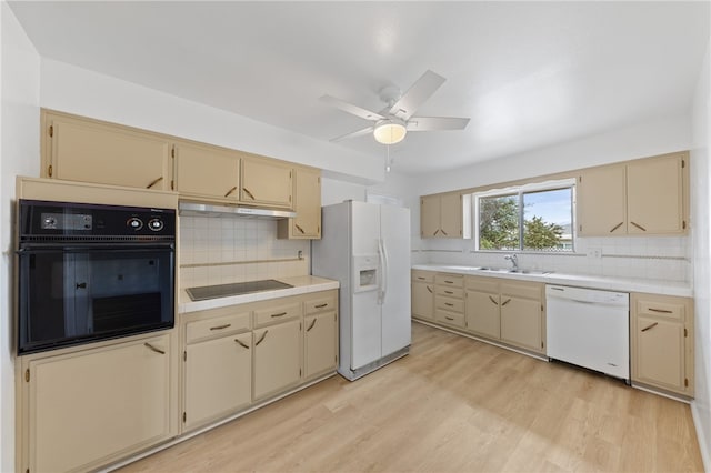 kitchen with black appliances, backsplash, light wood-type flooring, and sink