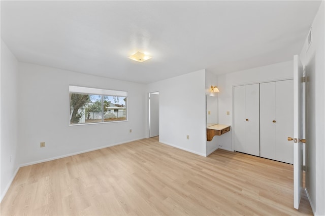 unfurnished bedroom with a closet and light hardwood / wood-style floors