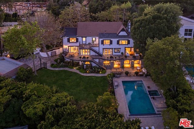 back of house with a patio and a lawn