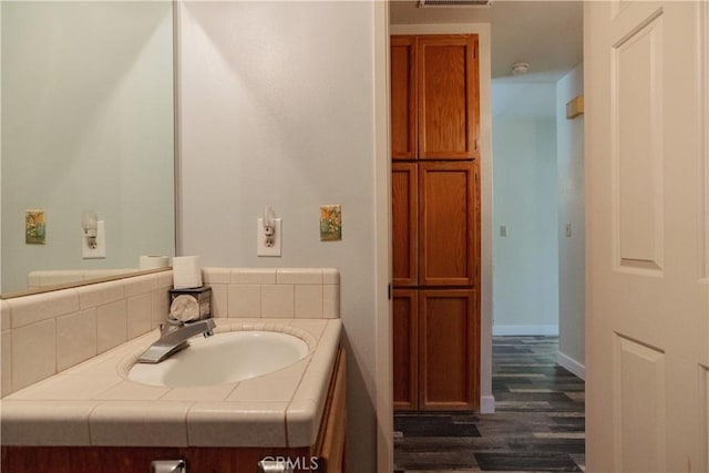 bathroom featuring decorative backsplash, hardwood / wood-style floors, and vanity