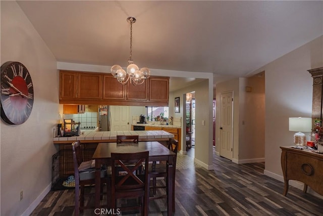 dining area featuring dark hardwood / wood-style floors and an inviting chandelier