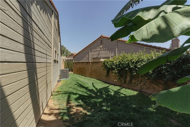 view of side of home with a yard and central AC unit