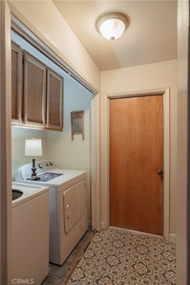 laundry room featuring washer and clothes dryer and cabinets