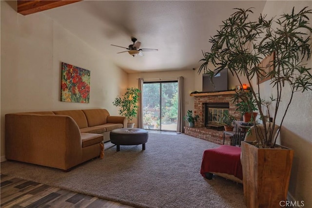 living room featuring hardwood / wood-style floors, vaulted ceiling with beams, a brick fireplace, and ceiling fan