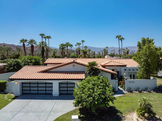 view of front of house featuring a front lawn, a mountain view, and a garage