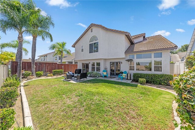 rear view of house featuring a yard, a patio, and an outdoor hangout area