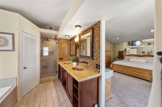 bathroom featuring backsplash, vanity, wood-type flooring, and walk in shower