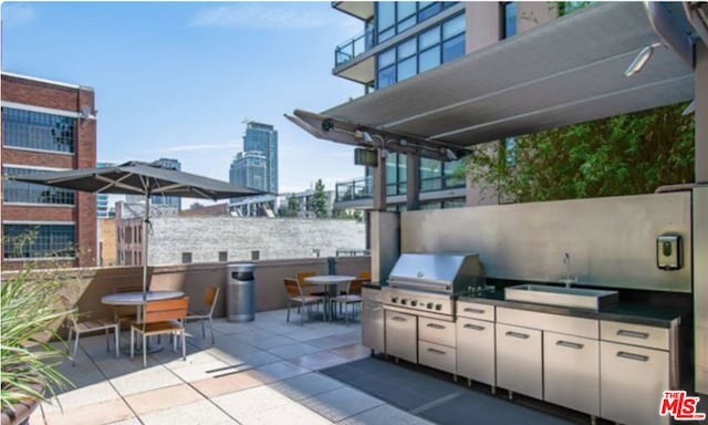 view of patio / terrace featuring exterior kitchen, a grill, and sink