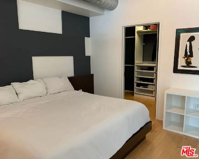 bedroom with wood-type flooring and a closet