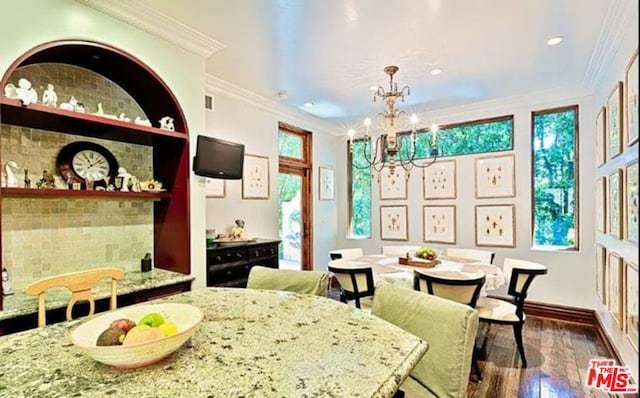 dining area with ornamental molding, dark wood-type flooring, and a chandelier