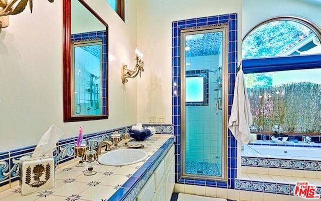 bathroom featuring tiled bath and vanity