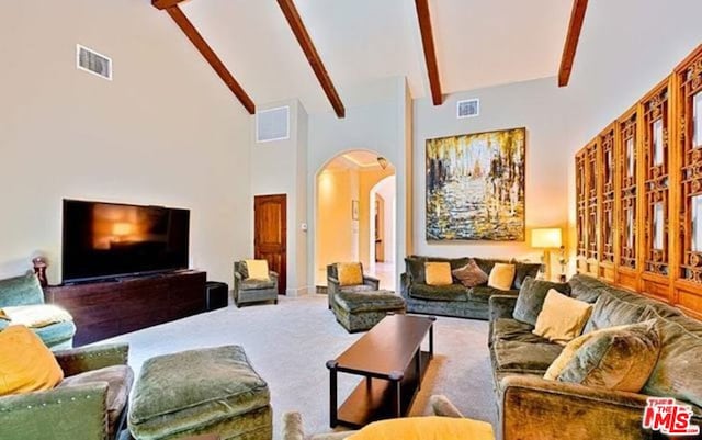 carpeted living room with high vaulted ceiling and beamed ceiling