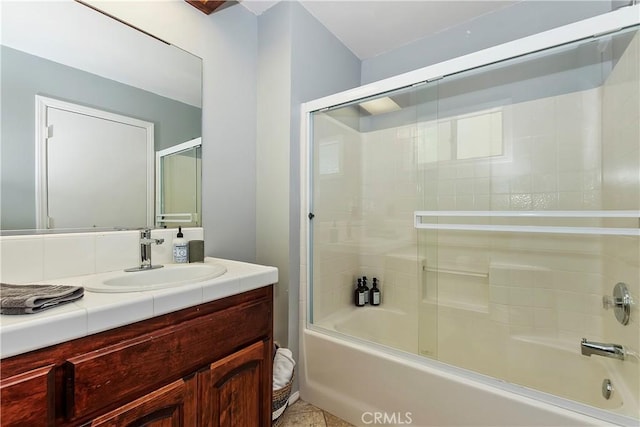 bathroom featuring tile patterned floors, enclosed tub / shower combo, and vanity