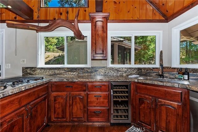 kitchen with lofted ceiling, dark wood-type flooring, wine cooler, sink, and stainless steel gas stovetop