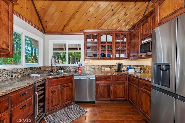 kitchen with dark stone counters, stainless steel appliances, wood ceiling, and wine cooler