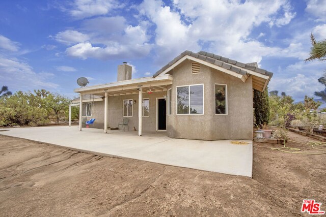 rear view of property featuring a patio and ceiling fan