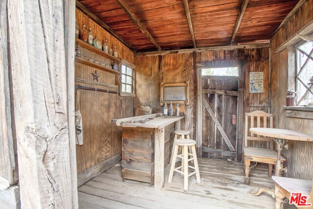 miscellaneous room with wooden walls, light hardwood / wood-style flooring, and wood ceiling